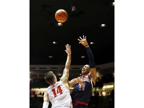 Arizona's Ira Lee, right, shoots the ball over New Mexico's Dane Kuiper in the first half of an NCAA college basketball game, Saturday, Dec. 16, 2017, in Albuquerque, N.M.
