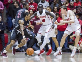 New Mexico State's AJ Harris, left,drives around the pick of teammate Johnathon Wilkins (11) and met by the New Mexico defense of Makuach Maluach (10) and Joe Furstinger, right, during the first half of an NCAA college basketball game in Albuquerque, N.M., Saturday, Dec. 9, 2017.