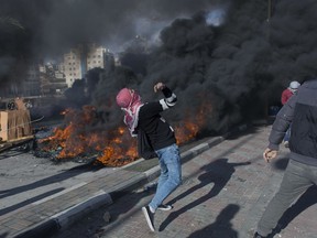 Palestinian protesters clash with Israeli troops following protests against U.S. President Donald Trump's decision to recognize Jerusalem as the capital of Israel, in the West Bank city of Ramallah, Thursday, Dec. 7, 2017.