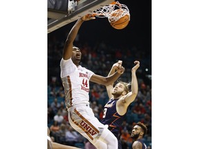 UNLV's Brandon McCoy dunks over Illinois' Michael Finke during the first half of an NCAA college basketball game Saturday, Dec. 9, 2017, in Las Vegas.