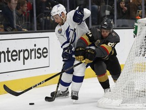 Tampa Bay Lightning defenseman Dan Girardi, left, and Vegas Golden Knights center Jonathan Marchessault battle for the puck during the first period of an NHL hockey game, Tuesday, Dec. 19, 2017, in Las Vegas.