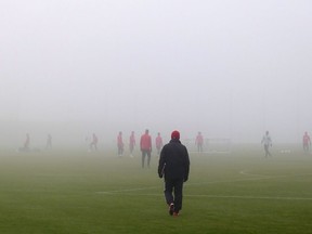 Toronto FC coach Greg Vanney walks across the pitch to a team practice in heavy fog, in Toronto on Sunday, December 3, 2017.