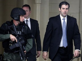 FILE - In this Monday, Dec. 5, 2016, file photo, former South Carolina police officer Michael Slager, right, walks from the Charleston County Courthouse under the protection of the Charleston County Sheriff's Department after a mistrial was declared for his trial in Charleston, S.C.  l Slager is in court Monday, Dec. 4, 2017, facing a possible life sentence for the April 2015 shooting death of Walter Scott. The foot chase and shooting were captured by a bystander on cellphone video that was seen by millions online. Slager pleaded guilty in May to violating Scott's civil rights. A state jury deadlocked last year on murder charges, which were dropped as part of his federal plea deal.