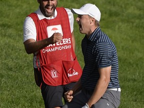 FILE - In this June 25, 2017, file photo, Jordan Spieth celebrates with caddy Michael Greller after sinking a shot from a bunker on the first playoff hole during the final round of the Travelers Championship golf tournament, in Cromwell, Conn. Spieth's bunker shot was the most memorable with a lob wedge.