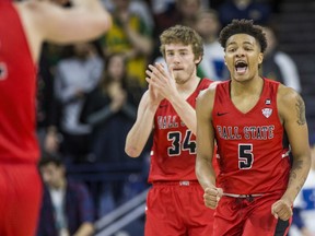 FILE - In this Dec. 5, 2017, file photo, Ball State's Ishmael El-Amin (5) and Sean Sellers (34) celebrate during the second half of an 80-77 win over Notre Dame in an NCAA college basketball game, in South Bend, Ind. This season was supposed to be different. Players talked openly about a third straight 20-win season, pursuing their first league title in 18 seasons, celebrating their first NCAA tourney win since 1990 and, yes, even adding a banner or two to the dusty collection. Everything changed for the Cardinals when 19-year-old 6-foot-9 forward Zach Hollywood was found dead in his apartment after committing suicide. Players wear a patch bearing Hollywood's initials just above their hearts.