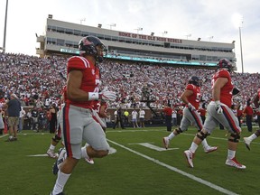 FILE - In this Sept. 2, 2017, file photo, Mississippi players take the field before an NCAA college football game against South Alabama in Oxford, Miss. Mississippi's football program has been handed a two-year postseason ban and other penalties by the NCAA, on Friday, Dec. 1, 2017. The NCAA came down hard on Ole Miss for its long-running rules violation case that included a charge of lack of institutional control. (AP Photo/Thomas Graning, File)