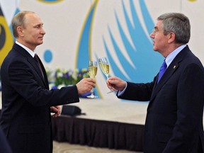 FILE - In this Feb. 24, 2014, file photo, Russian President Vladimir Putin, left, toasts a glass of champagne with the International Olympic Committee President Thomas Bach during the official reception of IOC for Sochi 2014 Winter Olympics organizing committee in Sochi, Russia. Russia's booted from Pyeongchang, Its Sochi Games now boomerang. But while the IOC says "nyet," It finds a way to hedge its bet. Clean Russians get the welcome mat, And Putin's surely fine with that.