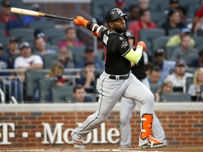 FILE - In this Sept. 7, 2017, file photo, Miami Marlins' Marcell Ozuna watches his RBI triple during the first inning of a baseball game against the Atlanta Braves, in Atlanta. A person familiar with the negotiations says Miami has agreed to trade left fielder Marcell Ozuna to the St. Louis Cardinals, the third All-Star jettisoned by the Marlins this month in an unrelenting payroll purge under new CEO Derek Jeter. The person spoke to The Associated Press on condition of anonymity Wednesday because the agreement had not been announced and was subject to a physical.