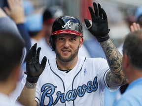 FILE - In this Saturday, June 17, 2017 file photo, Atlanta Braves first baseman Matt Adams (18) celebrates in the dugout after hitting a two run home run in the third inning of a baseball game against the Miami Marlins in Atlanta. A person familiar with negotiations says the Washington Nationals have agreed to terms in principle on a $4 million, one-year contract with first baseman Matt Adams, a deal pending a successful physical, Wednesday, Dec. 20, 2017.