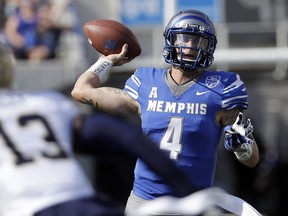 FILE - In this Oct. 14, 2017, file photo, Memphis quarterback Riley Ferguson (4) passes as he is pressured by Navy safety Juan Hailey (13) in the first half of an NCAA college football game, in Memphis, Tenn. Wide receiver Anthony Miller came to Memphis as a local preferred walk-on. Quarterback Riley Ferguson started at the Southeastern Conference school on the other side of the state before Mike Norvell lured him to town. Together, they've helped the 16th-ranked Tigers reach the American Athletic Conference championship against No. 12 UCF with a chance at the program's best season ever.