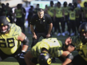 FILE - In this Oct. 28, 2017, file photo, Oregon co-offensive coordinator Mario Cristobal watches a special team warmup drill before an NCAA college football game against Utah, in Eugene, Ore. A person with direct knowledge of the situation says Oregon will hire Mario Cristobal as its head coach. The person spoke to The Associated Press on condition of anonymity because a deal and announcement were still being finalized. Cristobal was offensive coordinator at Oregon this past season and was named interim coach on Tuesday, Dec. 5, 2017, when Willie Taggart left to become coach at Florida State.