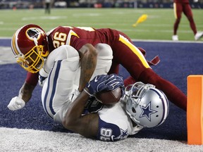 FILE - In this Nov. 30, 2017, file photo, Washington Redskins cornerback Bashaud Breeland (26) lands on top of Dallas Cowboys wide receiver Dez Bryant (88) after Bryant caught a pass for a touchdown in the second half of an NFL football game, in Arlington, Texas. Informed that one estimation gives his Washington Redskins a 1 percent chance of making the playoffs, cornerback Bashaud Breeland opted to take a rose-colored view of the situation. "So we still have something we can play for," Breeland said after an abbreviated practice Monday, Dec. 4, 2017. "It's not all the way out of our grasp."