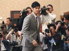 FILE - In this Nov. 11, 2017, file photo, Japanese pitcher-outfielder Shohei Ohtani arrives for a press conference at the Japanese National Press Center in Tokyo. Japanese star Shohei Ohtani is bringing his arm and bat to the Los Angeles Angels, pairing him with two-time MVP Mike Trout. Ohtani's agent put out a statement Friday, Dec. 8, 2017, saying the prized two-way player had decided to sign with the Angels, a surprise winner over Seattle, Texas and several other teams.