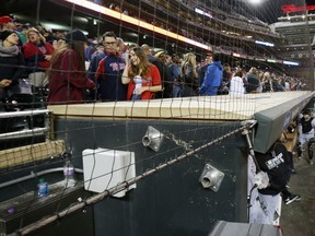 In this Wednesday, April 13, 2016 file photo, Minnesota Twins front row fans have protective netting to look through over the dugouts as they watch baseball games at Target Field where they took in the Twins and Chicago White Sox game in Minneapolis. The Cleveland Indians and Minnesota Twins are the latest Major League Baseball teams to announce plans for expansions of safety netting at their ballparks for the 2018 season.