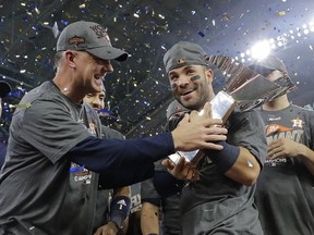 FILE - In this Oct. 21, 2017, file photo, Houston Astros manager A.J. Hinch and Jose Altuve hold the championship trophy after Game 7 of baseball's American League Championship Series against the New York Yankees, in Houston. Altuve was named The Associated Press Male Athlete of the Year on Wednesday, Dec. 27, 2017.
