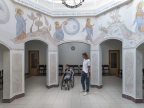 Tutor Valeria and 11-year-old pupil Feruza cross through a chapel at the St. Sophia orphanage in Moscow, Russia, on Tuesday, Sept. 12, 2017. According to Russian officials, the number of children without parents or guardians has declined almost 50 percent in recent years, from about 126,000 in 2011 to 66,000 in 2016. But recent data indicates only a few hundred are placed with foster families each year and there's been no major surge in adoptions.