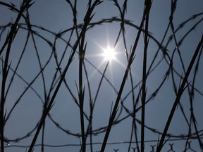 ADVANCE FOR RELEASE SUNDAY, DEC. 31, 2017 AND THEREAFTER -FILE - In this Saturday, April 26, 2014 file photo, the sun shines through concertina wire on a fence at the Louisiana State Penitentiary in Angola, La. Nearly two years after the January 2016 U.S. Supreme Court ruling that prison inmates who killed as teenagers are capable of change and may deserve eventual freedom, the question remains unresolved: Which ones should get a second chance?