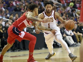 FILE - In this Nov. 3, 2017, file photo, Cleveland Cavaliers' Derrick Rose (1) dribbles against Washington Wizards forward Kelly Oubre Jr., left, during the first half of an NBA basketball game in Washington. Cavaliers coach Tyronn Lue says the team's communication with embattled point guard Rose has been positive. Rose is away from the team because of a personal matter. He also has been sidelined by a sprained left ankle.