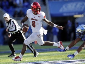 FILE - In this Nov. 25, 2017, file photo, Louisville quarterback Lamar Jackson (8) scrambles past Kentucky defensive tackle Kordell Looney during the second half of an NCAA college football game in Lexington, Ky. Jackson, Oklahoma quarterback Baker Mayfield and Stanford running back Bryce Love were chosen as finalists for the Heisman Trophy on Monday, Dec. 4, 2017.