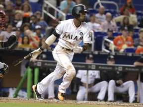 FILE - In this Sept. 30, 2017, file photo, Miami Marlins' Dee Gordon hits a single during the fifth inning of a baseball game against the Atlanta Braves in Miami. Gordon has been traded to the Seattle Mariners for three prospects in a deal that marks the start of the Marlins' latest payroll purge, this time under new CEO Derek Jeter.