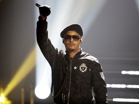 FILE - In this Sept. 17, 2016, file photo, T.I. performs during the BET Hip Hop Awards in Atlanta. Rapper T.I. spent Christmas eve spreading holiday cheer among some single mothers, helping them with their last-minute shopping for gifts. In a video T.I. posted on social media, the Grammy-winning artist entered an Atlanta-area Target on Sunday, Dec. 24, 2017, and called for all single mothers present to follow him. He strolled through the store alongside several mothers, went to the cash register with them and then paid for their Christmas presents.