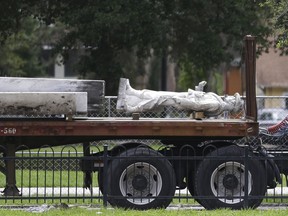 FILE - In this June 20, 2017, file photo, the top section of a Confederate statue called "Johnny Reb" is loaded on a truck before being removed from a downtown park in Orlando, Fla. WFTV-TV reported Wednesday, Dec. 6, that the statue now stands in Orlando's Greenwood Cemetery.