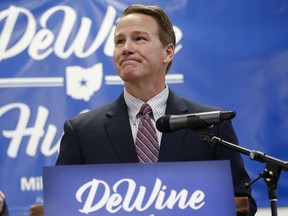 FILE - In this Nov. 30, 2017, file photo, Ohio Secretary of State Jon Husted, right, pauses as he speaks during a news conference at the University of Dayton in Dayton, Ohio. Husted, Ohio's elections chief wants Ohio counties to modernize their voting machines before the 2020 presidential election, and he's urging the governor and state lawmakers to foot much of the bill.