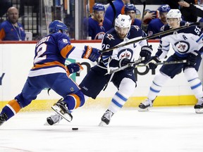 Winnipeg Jets right wing Blake Wheeler (26) battles for the puck with New York Islanders defenseman Nick Leddy (2) in the first period of an NHL hockey game, Saturday, Dec. 23, 2017, in New York.