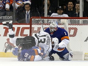 Los Angeles Kings' Kyle Clifford (13) falls on top of New York Islanders defenseman Adam Pelech (50) and collides with Islanders goalie Thomas Greiss in the second period of an NHL hockey game, Saturday, Dec. 16, 2017, in New York.