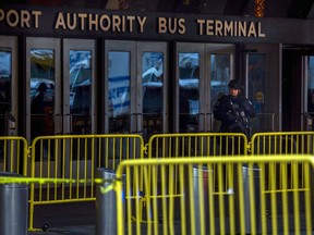 A police officer stands guard in front of Port Authority Bus Terminal as law enforcement respond to a report of an explosion near Times Square on Monday, Dec. 11, 2017, in New York.