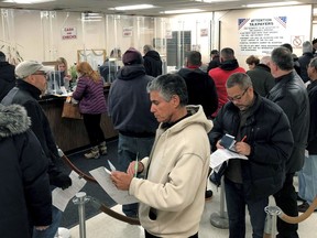 In this Dec. 26, 2017 photo, people line-up at the Town of Hempstead tax receiver's office to pay their real estate taxes before the end of the year, hoping for one last chance to take advantage of a major tax deduction before it is wiped out in the new year. The tax overhaul signed last week by President Donald Trump puts a new $10,000 limit on the amount of state and local taxes people can deduct from their income when calculating their federal tax liability.