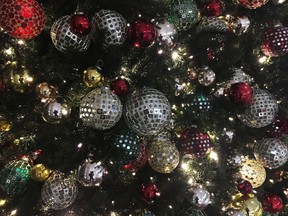 In this Friday, Dec. 1, 2017, photo, ornaments hang on a Christmas tree on display in New York. The office holiday party is getting shaken up as reports of sexual misconduct by famous and powerful men have many companies thinking harder about how to stop bad behavior in the workplace. A survey shows fewer companies will serve alcohol this year than last year, but HR experts say that's not enough.