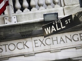 FILE - This July 16, 2013, file photo, shows a Wall Street street sign outside the New York Stock Exchange. Stock markets are mostly higher on Monday, Dec. 11, 2017, as upbeat U.S. jobs data from a week earlier and signs of progress in the Brexit talks continued to support investor sentiment.