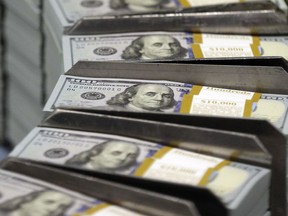 FILE - In this Sept. 24, 2013, file photo, just cut stacks of $100 bills make their way down the line at the Bureau of Engraving and Printing Western Currency Facility in Fort Worth, Texas. Big U.S. companies have been piling up cash for years, but have spent little of it on buying equipment and raising wages and other things to grow the economy. Republicans say they know how to fix this: Give companies even more money by cutting their taxes.