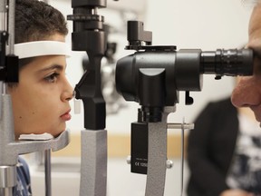 FILE - In this Oct. 4, 2017, file photo, Dr. Albert Maguire, right, checks the eyes of Misa Kaabali, 8, at the Children's Hospital of Philadelphia. Misa was 4-years-old when he received his gene therapy treatment. On Tuesday, Dec. 19, 2017, the Food and Drug Administration approved the therapy which improves the vision of patients with a rare form of inherited blindness, another major advance for the burgeoning field of genetic medicine.