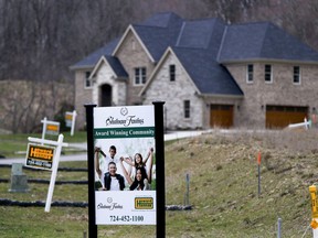 FILE - In this Monday, Feb. 27, 2017, file photo, real estate signs mark the lots near one of the new homes for sale in a development for new homes in Cranberry Township, Butler County, Pa. On Thursday, Dec. 7, 2017, Freddie Mac reports on the week's average U.S. mortgage rates.