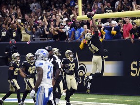 FILE - In this Oct. 15, 2017, file photo, New Orleans Saints defensive end Cameron Jordan (94) celebrates after returning an interception for touchdown by dunking the football over the goal post in the second half of an NFL football game against the Detroit Lions in New Orleans. Jordan's love of basketball was arguably counterproductive when he was flagged and fined for celebrating by dunking the ball over the goal post. But when Jordan talks about pursuing a "triple-double" in season sacks, tackles for loss and passes defended, coach Sean Payton is all about it.