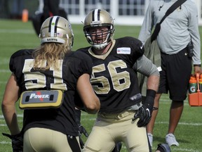 FILE - In this Aug. 15, 2016 file photo, New Orleans Saints outside linebacker Michael Mauti (56) works with linebacker Jeff Schoetter (51) in a drill during the NFL football teams training camp in White Sulphur Springs, W.Va.   Mauti became so fearful of food in recent years that even the thought of a holiday dinner gave him high anxiety. It took career-threatening surgeries and the removal of his large intestine to treat his case of ulcerative colitis. But Mauti has made an unlikely return to the field with in a years' time. Now he's helping the Saints' push for the playoffs and also trying to help others in all walks of life who've struggled with diseases similar to his.
