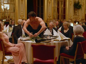 This image released by Magnolia Pictures shows Terry Notary, center, in a scene from "The Square." Notary plays a man who for his performance art, acts like an ape. He's been chosen as the entertainment for a group of well-heeled museum investors, but the interactive bit at a fancy dinner doesn't go as planned as he intimidates and terrorizes the nervous guests. (Magnolia Pictures via AP)