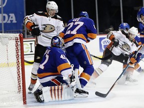 Anaheim Ducks' Andrew Cogliano (7) shoots the puck past teammate Hampus Lindholm (47) and New York Islanders goalie Jaroslav Halak (41) for a goal during the first period of an NHL hockey game Thursday, Dec. 21, 2017, in New York.