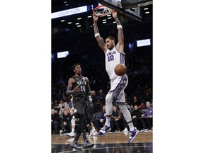 Sacramento Kings' Willie Cauley-Stein (00) dunks the ball in front of Brooklyn Nets' Rondae Hollis-Jefferson (24) during the first half of an NBA basketball game Wednesday, Dec. 20, 2017, in New York.
