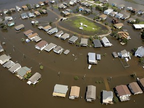 FILE- In this Sept. 1, 2017, file photo, homes are surrounded by flood water in the aftermath of Hurricane Harvey near Galveston, Texas. More than three months after Hurricane Harvey walloped Texas, many affected residents say they're still not getting help they need and President Donald Trump is getting low marks for his handling of the disaster, according to a Kaiser Family Foundation/Episcopal Health Foundation survey released Tuesday, Dec. 4.