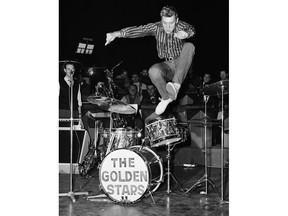 FILE - This Oct. 22 1962 shows French pop singer, Johnny Hallyday, leaps into the air whilst rehearsing at the Olympia Theater in Paris. The French president's office says Hallyday, who packed sports stadiums for decades, has died at age 74.