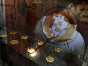 FILE- In this Friday, Dec. 8, 2017, file photo, a man uses a Bitcoin ATM in Hong Kong. Bitcoin is the world's most popular virtual currency. The latest example of a company trying to tie its fortunes to the cryptocurrency craze came Thursday, Dec. 21, in form of an iced tea maker.