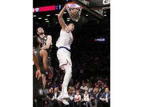 New York Knicks forward Kristaps Porzingis (6) dunks in front of Brooklyn Nets center Tyler Zeller (44) in the first half of an NBA basketball game, Thursday, Dec. 14, 2017, in New York.