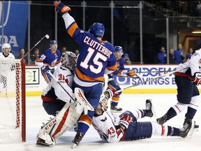 New York Islanders right wing Cal Clutterbuck (15) collides with Washington Capitals goalie Philipp Grubauer (31), of Germany, as Capitals right wing Tom Wilson (43) slides into Grubauer during the second period of an NHL hockey game in New York, Monday, Dec. 11, 2017.