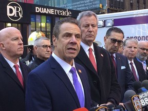 New York Gov. Andrew Cuomo speaks to members of the media after a pipe bomb strapped to a man went off in a New York City subway near Times Square on Monday, Dec. 11, 2017, in New York. Mayor Bill de Blasio stands fourth from left.