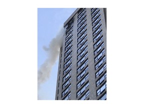 In this photo provided by WPIX-TV, smoke billows from the 35th floor of a Manhattan high rise building in which the The New York Police Department said a man in his 70's was killed, Monday, Dec. 25, 2017, in New York. New York Fire Department spokesman Michael Parrella says firefighters were hampered by high winds and malfunctioning elevators, delaying their ascent. Parella said two firefighters were also injured in the early morning fire.