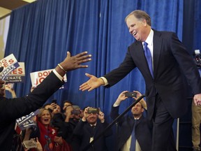 FILE - In a Tuesday, Dec. 12, 2017 file photo, Doug Jones is greeted by a supporter before speaking during an election-night watch party in Birmingham, Ala. A super PAC that spent millions of dollars backing Jones in Alabama's Senate race was heavily supported by the Democratic Senate Majority PAC. Chris Hayden, spokesman for the Senate Majority PAC, said Tuesday, Dec. 25 that the group "predominantly funded" the PAC called Highway 31, which sent out advertising and mailings to help defeat Republican Roy Moore.