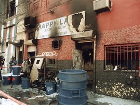 FILE - In this 1990 file photo, news crews report on an arson fire at the Happy Land social club in which 87 people perished, on March 25, 1990, in the Bronx borough of New York. On Thursday, Dec. 28, 2017, New York City's deadliest residential fire in decades spread through every floor of a Bronx apartment building within a matter of minutes, killing 12 people, city officials said.  Excluding the Sept. 11 attacks, it was the worst fire in the city since 87 people were killed at the social club fire in the Bronx in 1990. (AP Photo, File)